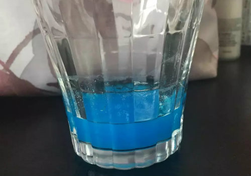 一种透明的蓝色溶液,放入深色饮料中溶解后可产生一种灰蒙蒙的颜色,这